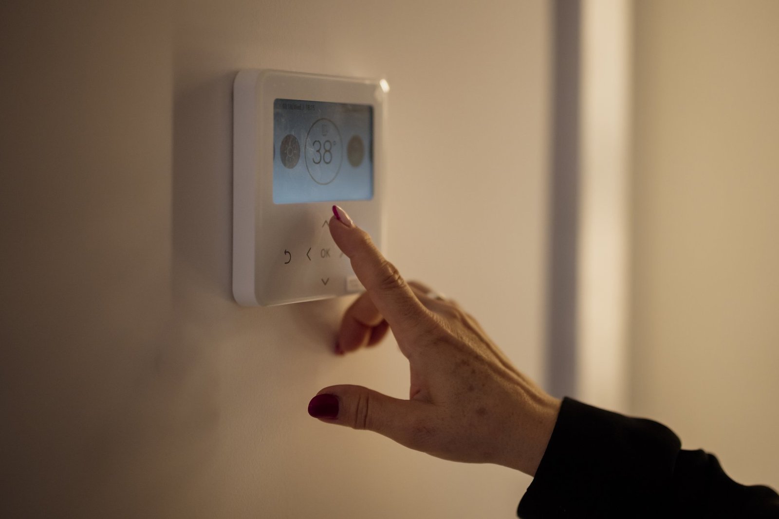 Real photograph of Google Nest Learning Thermostat installed on living room wall